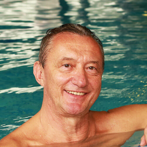 Natural Pharmaceuticals ProMan Plus Vyras šypsosi ir ilsisi baseine, atsipalaidavęs vandenyje.